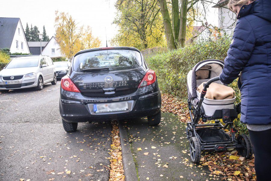 Eine Frau mit einem Kinderwagen kommt nicht am parkenden Auto vorbei. Muss sie mit Kind auf die Straße ausweichen, kann das gefährlich werden.  Foto: Max Rolke - Kreis Unna