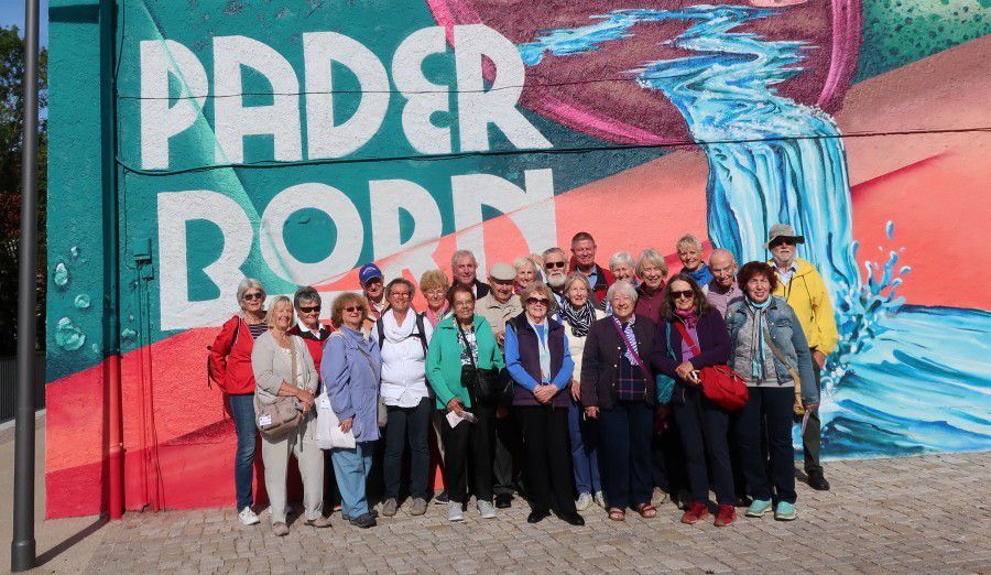 Das Foto zeigt die deutsche-englische Reisegruppe in Paderborn vor einer bunt bemalten Hausfassade. (Foto: privat)