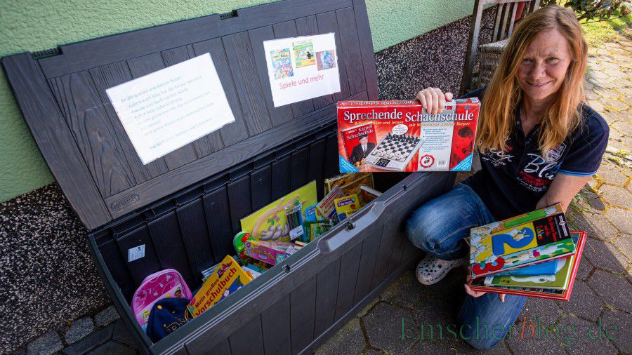 Ulrike Dürholt mit der Spiele- und Bücherkiste für Kinder: Die Box gegen die Langeweile steht vor ihrem Haus in der Melchiorstraße 4 und alle Kinder können sich daraus kostenlos bedienen. (Foto: P. Gräber - Emscherblog)