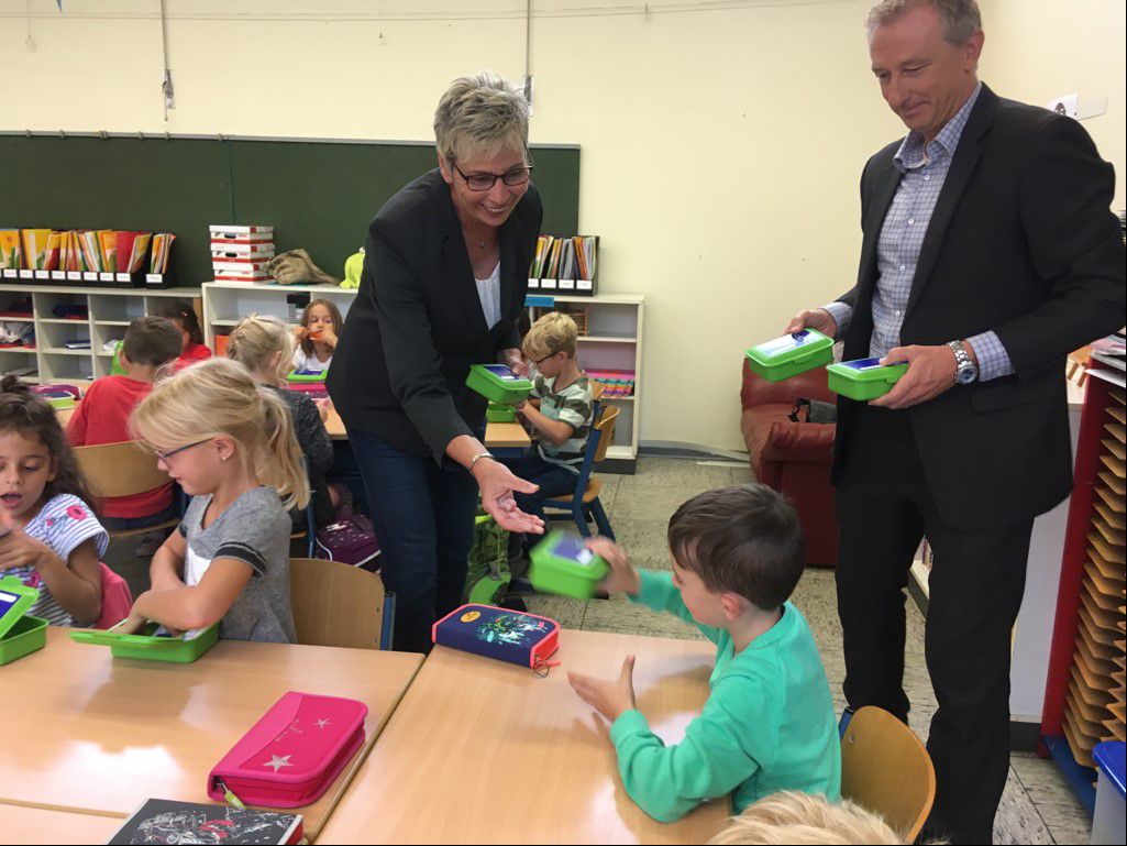 Bürgermeisterin Ulrike Drossel und Dirk Wißel, Kommunalbetreuer bei Innogy, verteilten heute Frühstücksboxen an die Schulanfänger der Nordschule. (Foto: Gemeinde holzwickede)