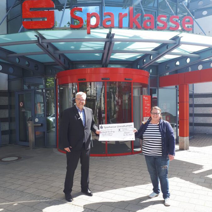 Der Leiter der Sparkasse Holzwickede, Dirk Röller, überreicht der Stadtradeln-Koordinatorin Tanja Flormann einen symblischen Spendenscheck über 250 Euro. (Foto: Gemeidne Holzwickede)