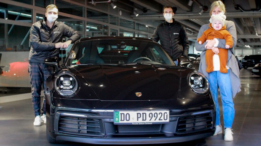 Übergabe eines Fahrzeuges an eine Kundin im Porsche-Zentrum Holzwickede durch die Mitarbeiter Robin Walther (li.) und Nils Feddersen. (Foto: Porsche Zentrum Dortmund)