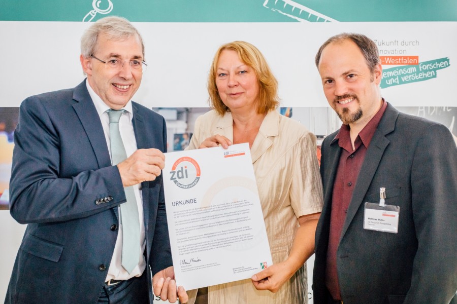 Klaus Kaiser (links) überreichte die Urkunde an Anita Flacke und Matthias Müller von der WFG.  (Foto zdi.NRW   Dominik Asbach)