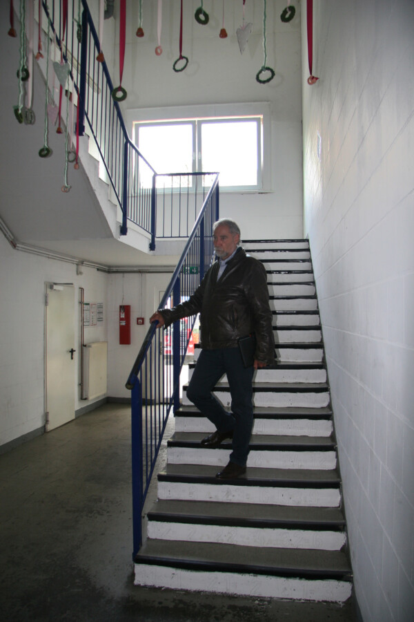 Die aktuelle Treppensituation im Qualifizierungszentrum, die Barriere für Menschen mit Behinderungen ist: Werkstatt-Geschäftsführer Herbert Dörmann auf der Treppe. (Foto: Mobilitat.de)