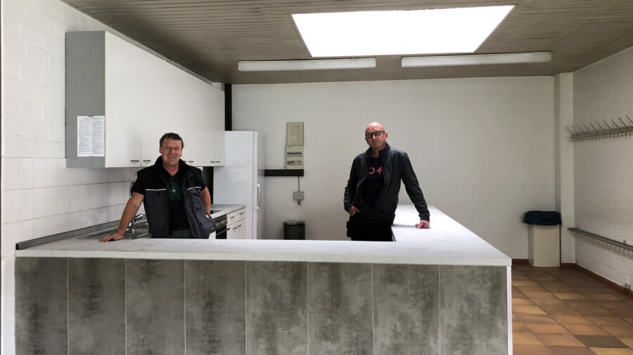Die neue Küche im Foyer der Hilgenbaumhalle ist einsatzbereit:  Die Hausmeister Ralf Wiese und Volker Krämer legten letzte Hand an. (Foto: gemeinde Holzwickede) 