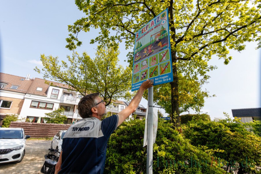 So wie hier für den Spielplatz am Düsseldorfer Weg, gab es auch für alle anderen Spielplätze der Gemeinde die  TÜV-Plakette: Prüfer Rainer Scharpenberg bringt sie gut sichtbar auf dem Spielplatzschild an. (Foto: P. Gräber - Emscherblog) 