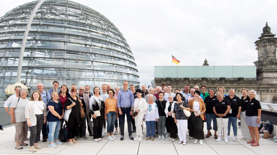 Die ehrenamtlich engagierten Bürgerinnen und Bürger aus dem Kreis Unna mit dem SPD-Bundestagsabgordneten Oliver Kaczmarek auf dem Reichstagsgebäude. (Foto: Bundesregierung - StadtLandMensch-Fotografie)